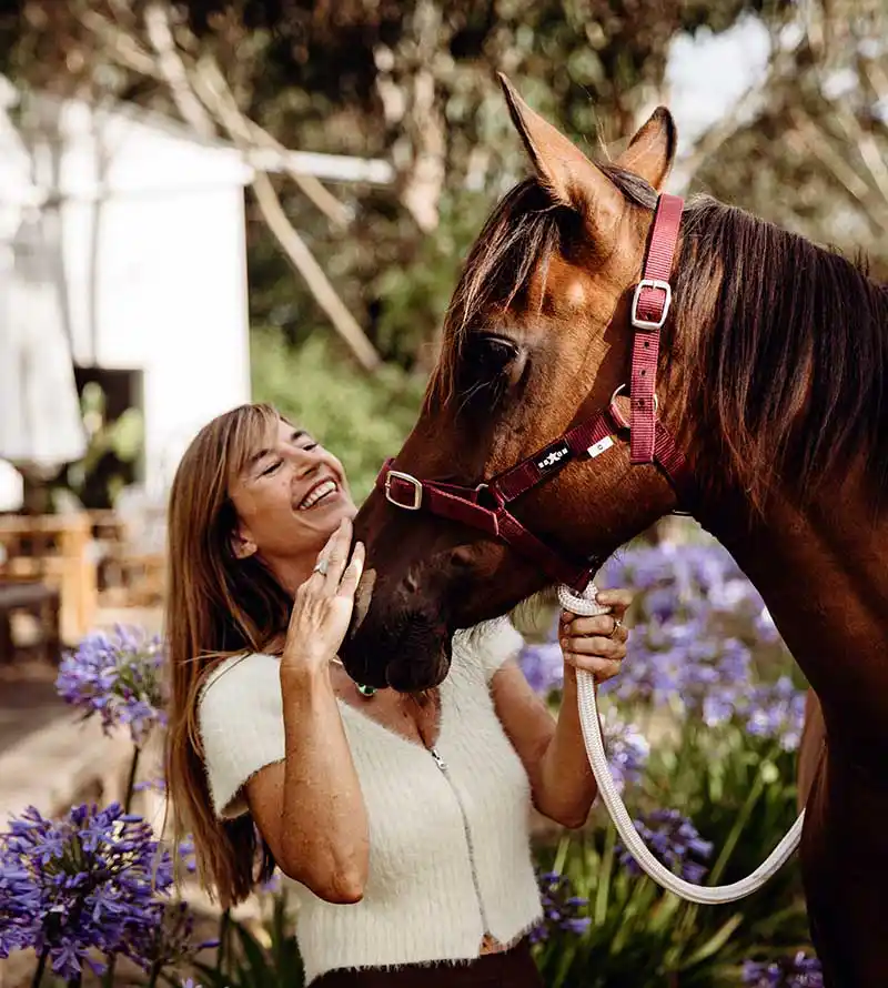 Meggin equine therapy horse and smiling therapist patting nose