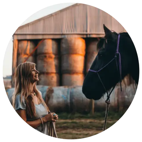 equine therapist with black horse outside barn
